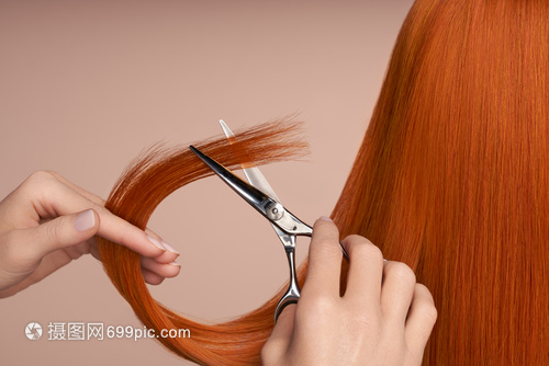 理发师用剪刀剪红色的长发发廊,发型师护理美容美发产品染了头发